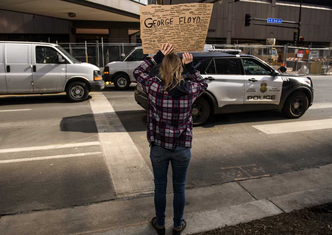 A Minneapolis Police cruiser drives by as people demonstrate outside the Hennepin County Government Center on March 9, 2021 in Minneapolis.