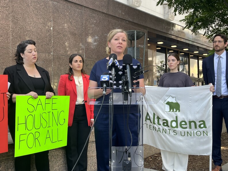 Pasadena renter Brenda Lyon speaks at a podium in front of a downtown Los Angeles courthouse.