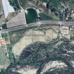 Aerial view of farms, vineyards, highway, and a river in a rural area.