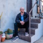 Joshua Cawthorn sits near where a pair of ADUs are supposed to be built on Dec. 20, 2024, in Hillcrest. (Ariana Drehsler / For The San Diego Union-Tribune)